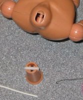 Now feed the elastic in, around the pin in the neck, and out